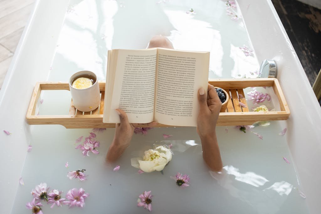 Woman reading book while resting in bathtub-pamper yourself at home