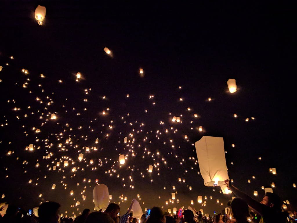A breathtaking view of floating lanterns illuminating the night sky during a vibrant festival.