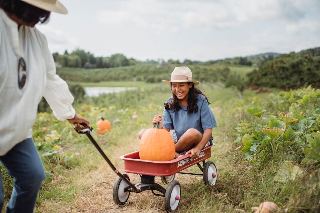 A girl riding in a wagon with a pumpkin on a lush green farm.
Best Fall Date Ideas for Couples in 2025: Cozy, Romantic & Fun